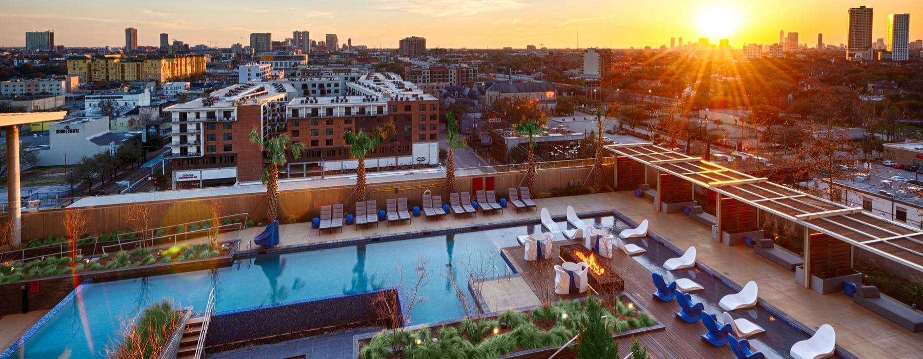 a pool and buildings with a sunset